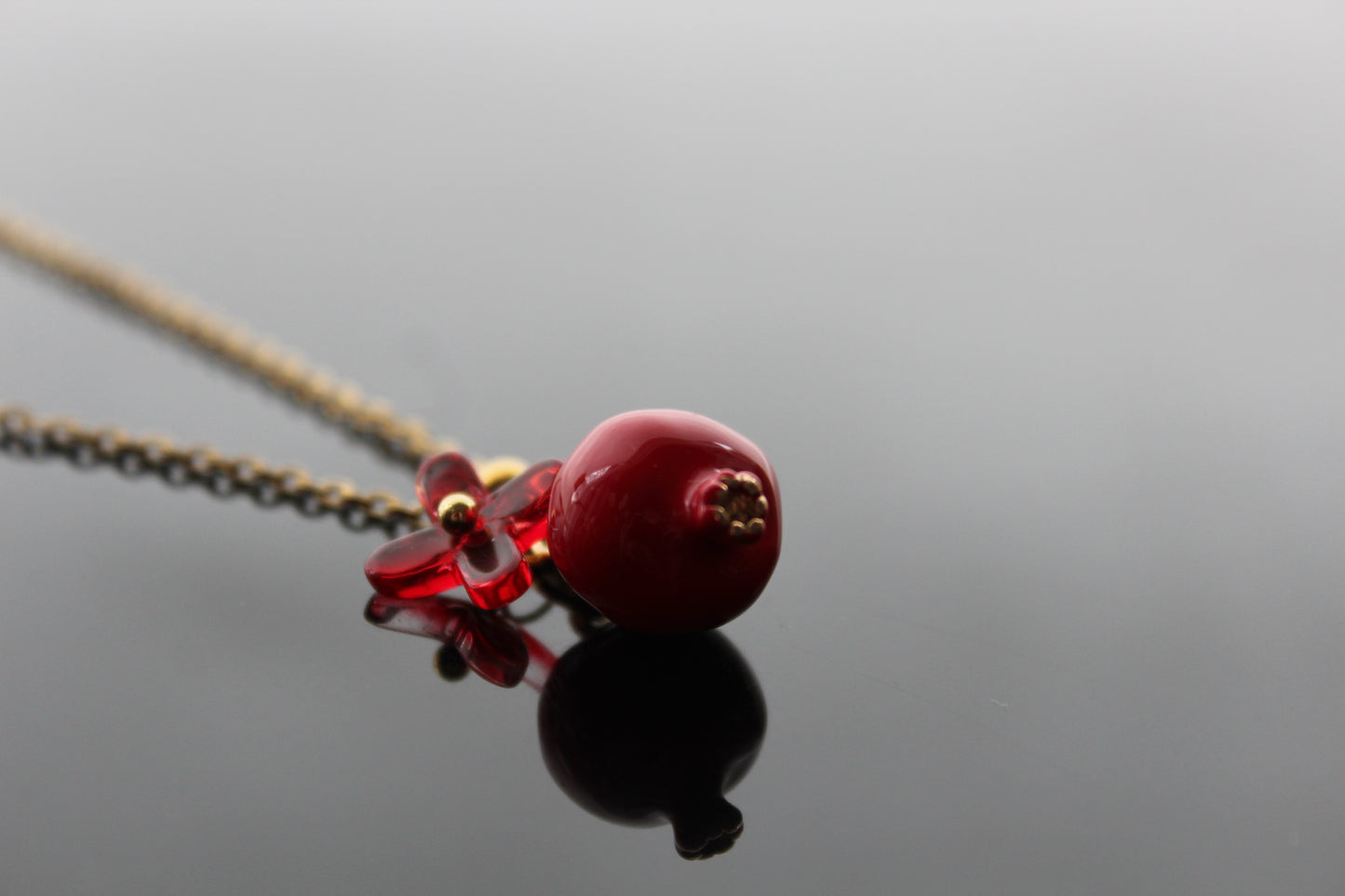 Handmade pomegranate enamel pendant with glass flower and enamel green leaf